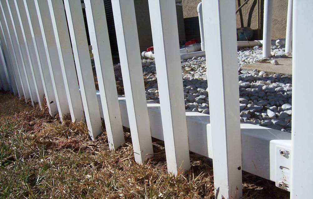 The same vinyl fence bright white after cleaning