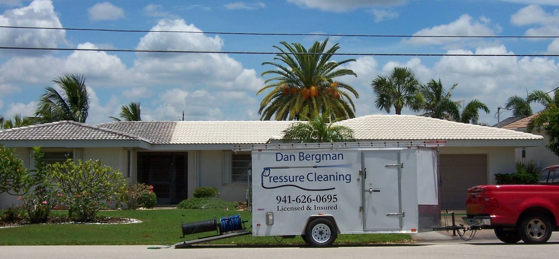 The branded trailer and truck outside a home with a freshly cleaned white tile roof